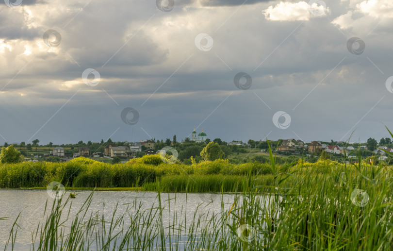 Скачать закатное небо над рекой, на заднем плане деревня с церковью фотосток Ozero