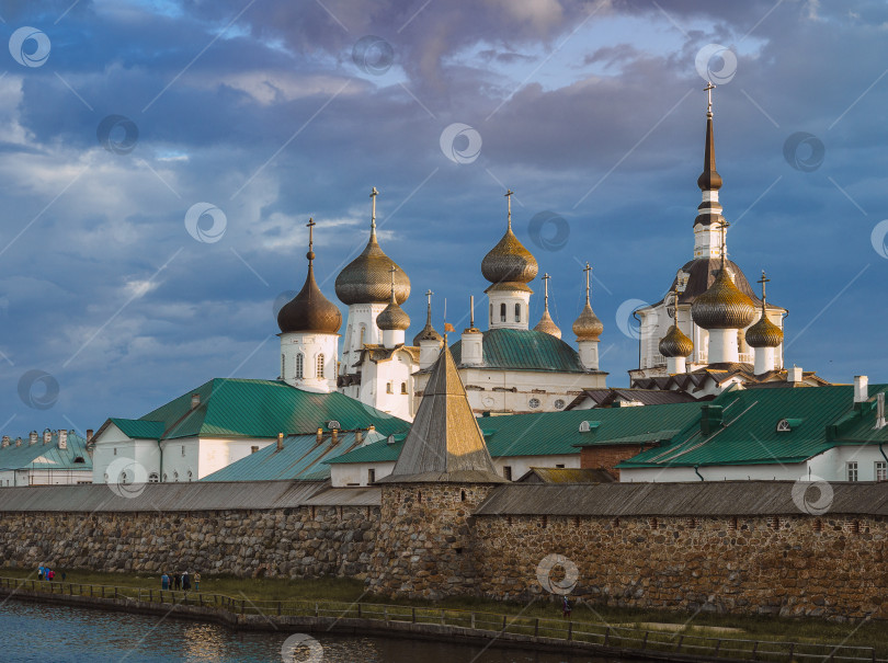 Скачать Архитектурный ансамбль Соловецкого монастыря с православными крестами и деревянными луковками на фоне предгрозового неба фотосток Ozero