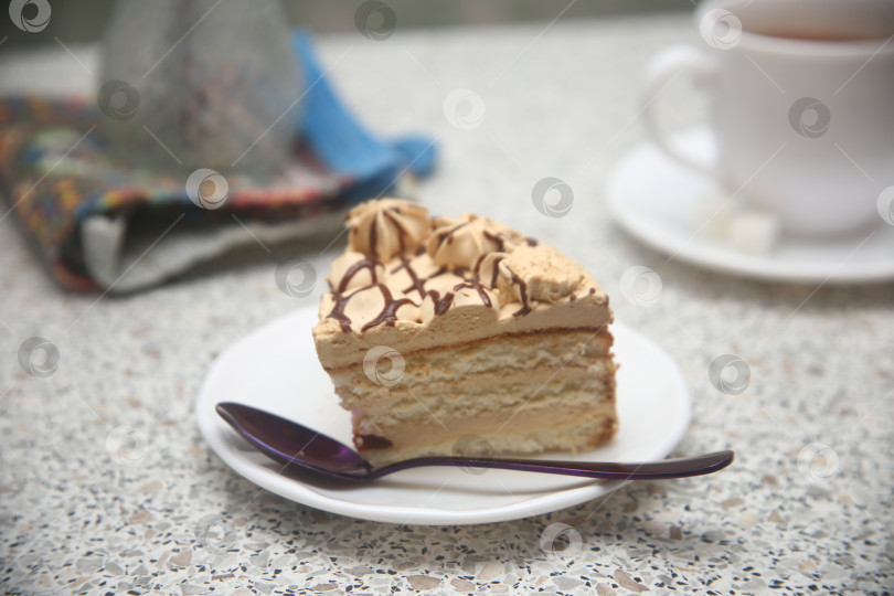 Скачать Кусок торт с карамельной прослойкой на блюдце с ложкой фотосток Ozero