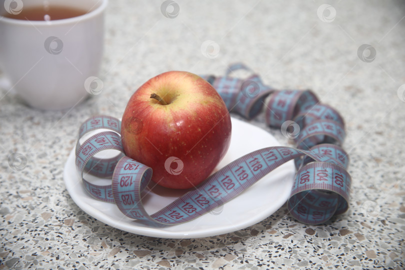 Скачать Яблоко в тарелке и сантиметр фотосток Ozero