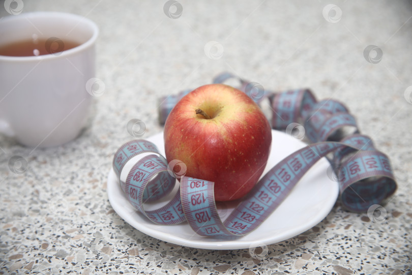 Скачать Яблоко в тарелке и сантиметровая лента фотосток Ozero