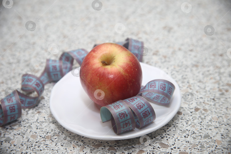 Скачать Яблоко красное в тарелке и сантиметр фотосток Ozero