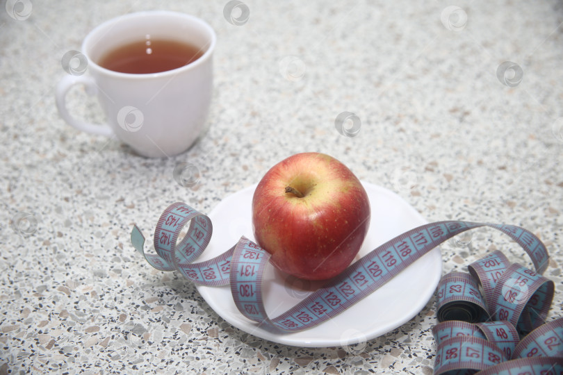 Скачать Яблоко красное и сантиметровая лента в тарелке фотосток Ozero