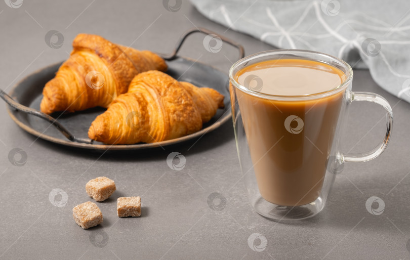Скачать Теплые круассаны и чашка кофе по утрам на столе в простой кухонной обстановке фотосток Ozero