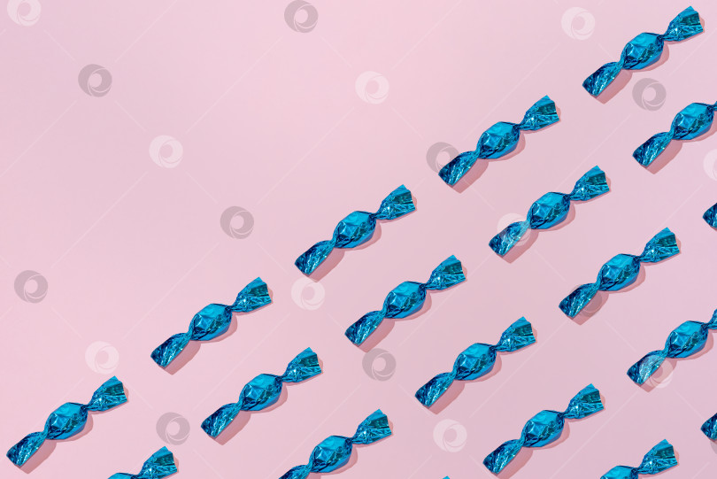 Скачать Креативный праздничный узор из голубых конфет на розовом фоне копирует пространство для текста фотосток Ozero