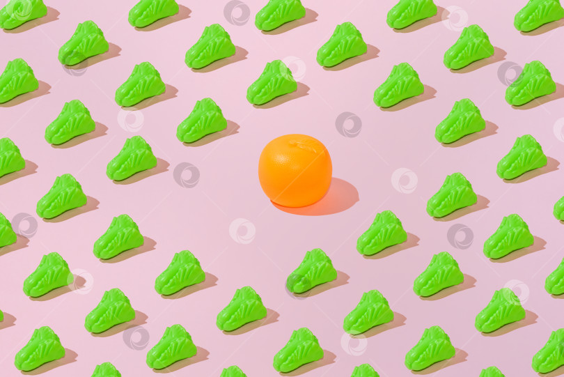 Скачать Креативный узор из салата и апельсина ровным слоем ложится на пастельно-розовый фон минимализм фотосток Ozero