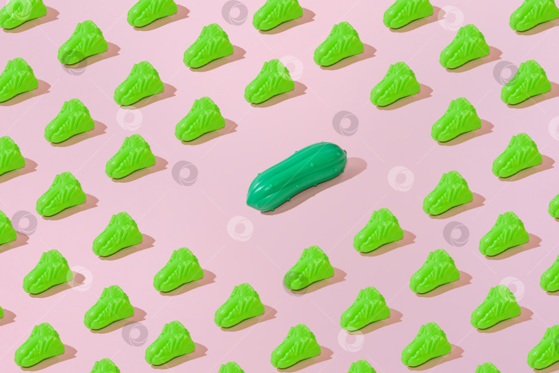 Скачать Креативный узор из салата и огурцов на ровном пастельно-розовом фоне, минимализм фотосток Ozero
