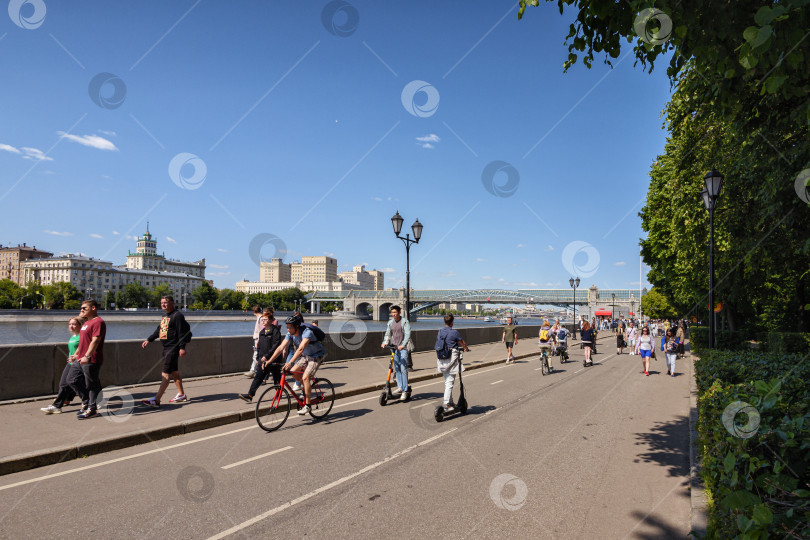 Скачать Прогулка горожан и катание на велосипедах по Пушкинской набережной Москвы-реки в солнечный летний день фотосток Ozero