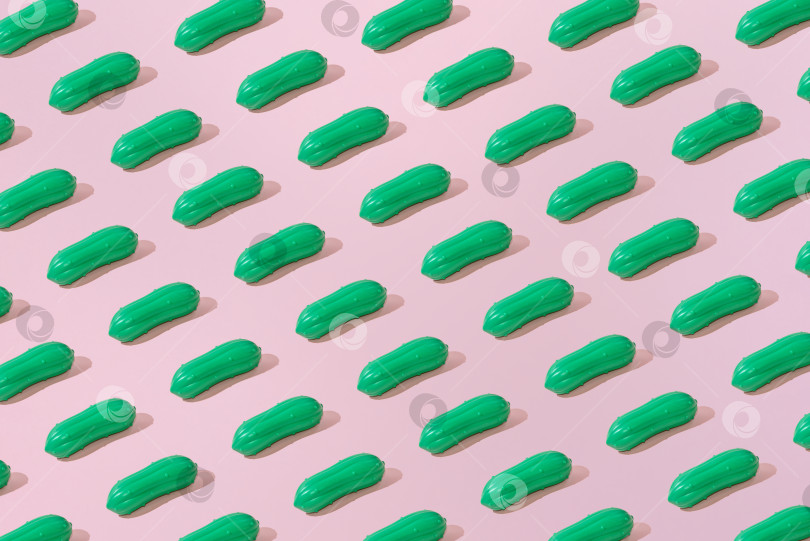 Скачать Креативный летний узор из огурцов ровным слоем ложится на пастельно-розовый фон минимализм фотосток Ozero
