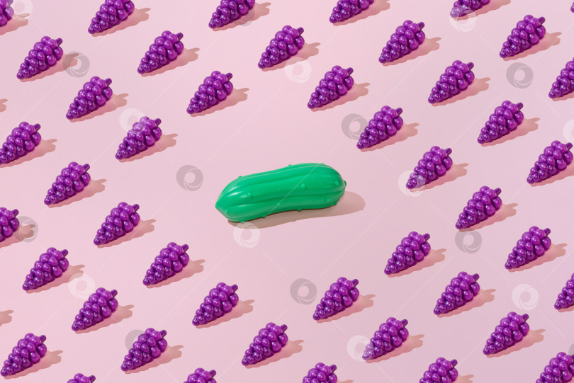 Скачать Креативный узор из винограда и огурцов на ровном пастельно-розовом фоне, минимализм фотосток Ozero