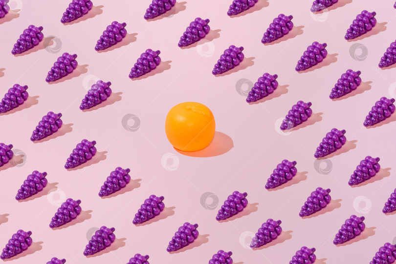Скачать Креативный узор из винограда и апельсина на ровном пастельно-розовом фоне, минимализм фотосток Ozero