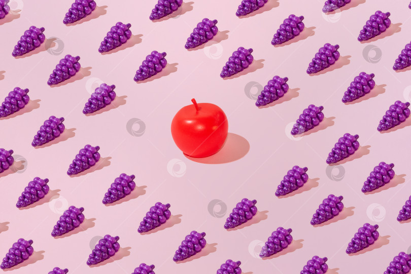 Скачать Креативный узор из винограда и яблок на ровном пастельно-розовом фоне минимализм фотосток Ozero