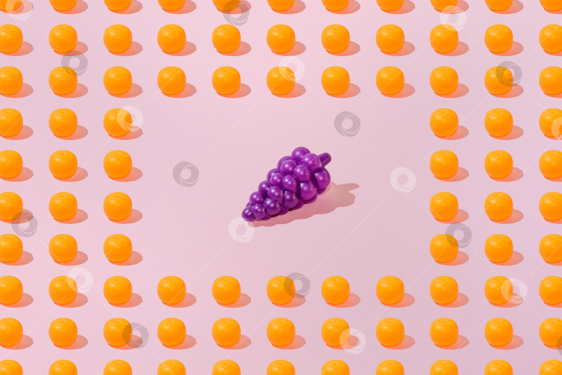 Скачать Креативный узор из апельсина и винограда ровным слоем ложится на пастельно-розовый фон минимализм фотосток Ozero