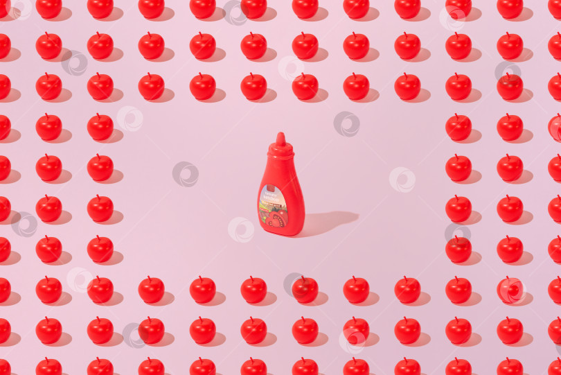 Скачать Креативный узор из яблок и кетчупа ровным слоем ложится на пастельно-розовый фон минимализм фотосток Ozero