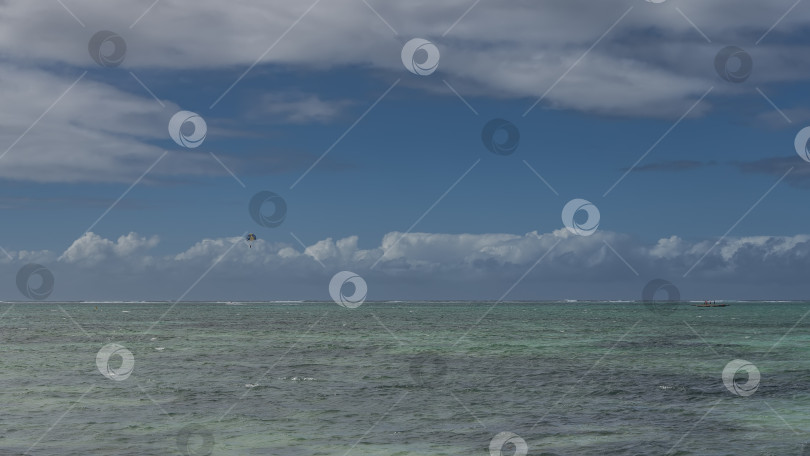 Скачать Над морем развевается разноцветный парашют. фотосток Ozero