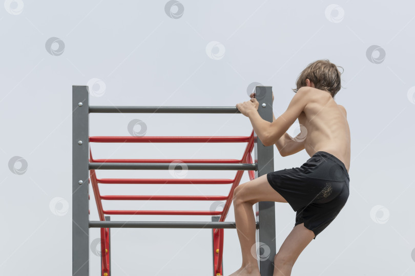 Скачать Маленький мальчик занимается на гимнастических снарядах фотосток Ozero