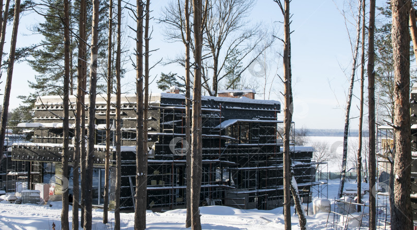 Скачать Строящийся частный дом в зимнем лесу фотосток Ozero