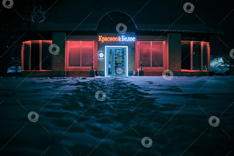 Скачать Краснознаменск, Россия, 31.12.2025, магазин алкоголя среди снега светится в ночи фотосток Ozero