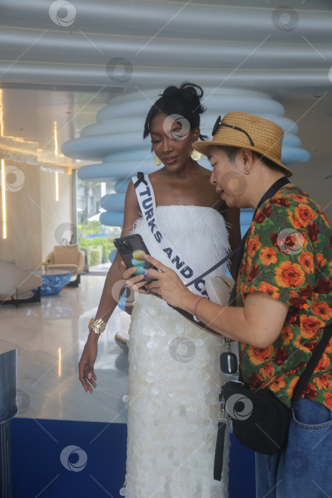 Скачать Пхукет, Таиланд, 9 ноября 2025 года: участницы конкурса "Мисс Вселенная-2025" позируют фотографам, блогерам и гостям на курорте Kora Beach Resort Phuket фотосток Ozero