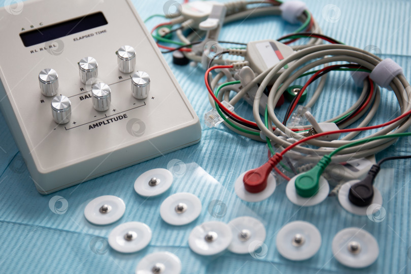 Скачать Устройство для расслабления височно-нижнечелюстного сустава с проводами и электродами на столе в стоматологии фотосток Ozero