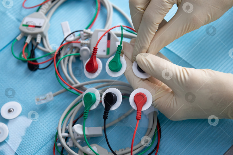 Скачать Руки в перчатках соединяют электроды для устройства стимуляции нервов в стоматологии фотосток Ozero