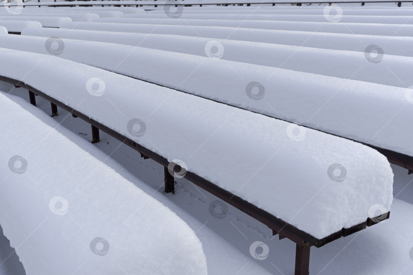 Скачать Заснеженные скамейки для зрителей в летнем театре. фотосток Ozero