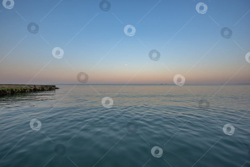 Скачать Восход солнца над морем спокойная водная гладь, уходящая к горизонту. фотосток Ozero