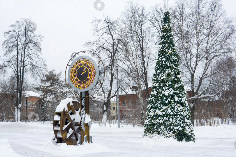 Скачать Часы и рождественская елка в городском парке зимой. фотосток Ozero