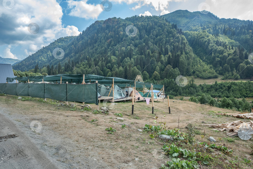 Скачать Россия  Абхазия 23 августа  2024г. Строительство палаточного городка и деревянные конструкции на фоне гор и леса в Абхазии. Небо с облаками. фотосток Ozero