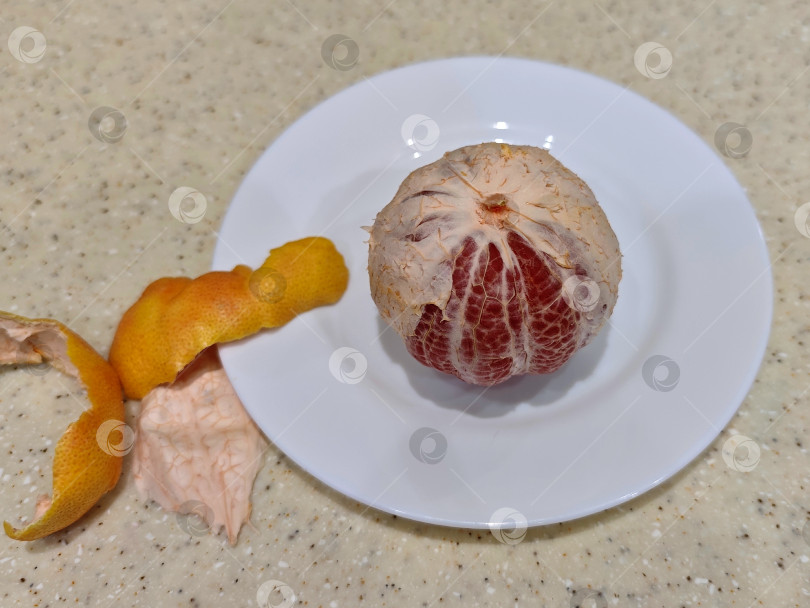 Скачать Красный грейпфрут на белой тарелке. Красный грейпфрут на белой тарелке. фотосток Ozero