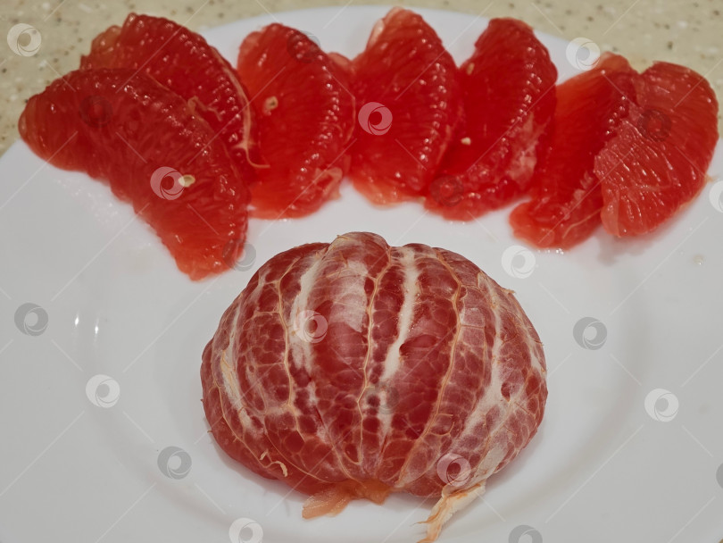 Скачать Красный грейпфрут на белой тарелке. фотосток Ozero