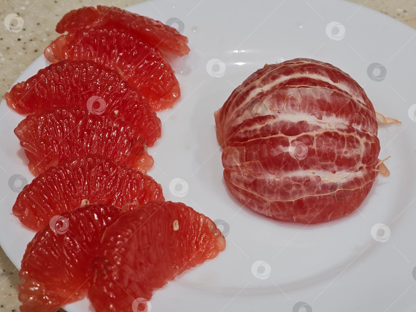 Скачать Красный грейпфрут на белой тарелке. фотосток Ozero