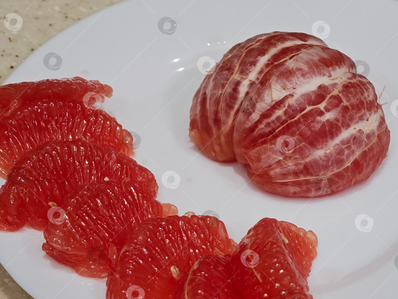 Скачать Красный грейпфрут на белой тарелке. фотосток Ozero