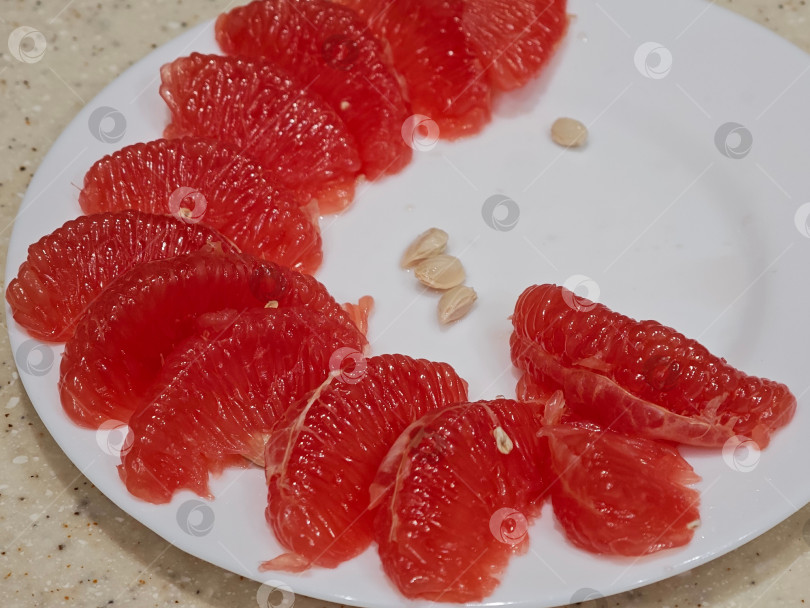 Скачать Красный грейпфрут на белой тарелке. фотосток Ozero