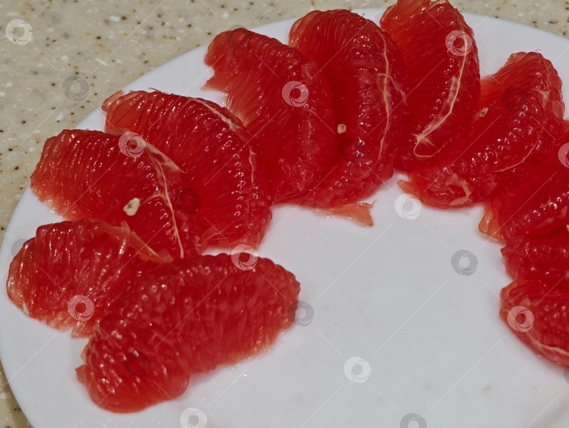 Скачать Красный грейпфрут на белой тарелке. фотосток Ozero