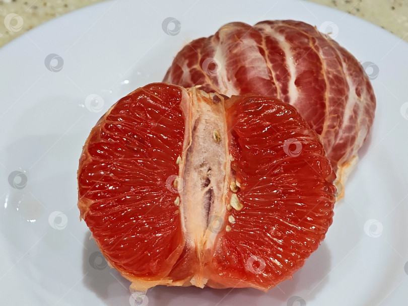 Скачать Красный грейпфрут на белой тарелке. фотосток Ozero