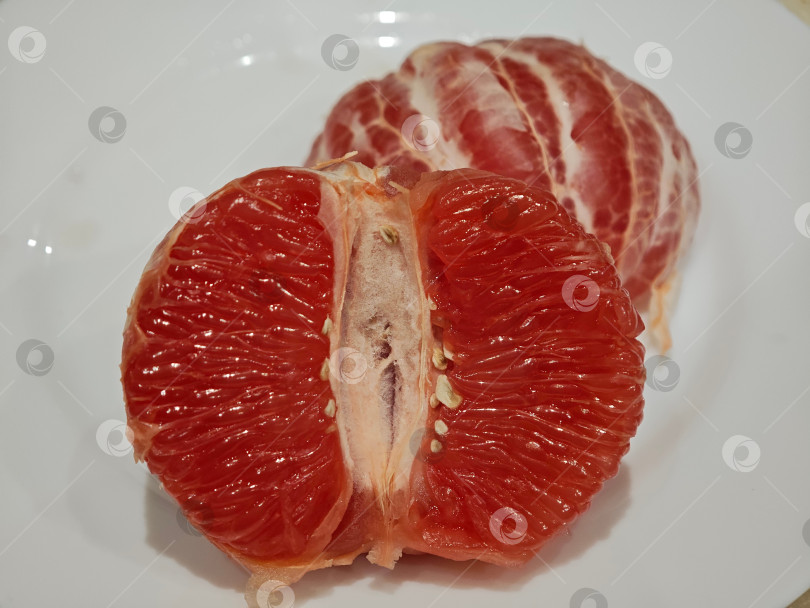 Скачать Красный грейпфрут на белой тарелке. фотосток Ozero