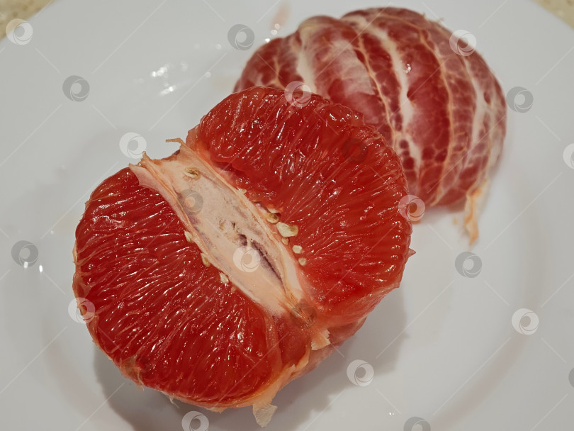 Скачать Красный грейпфрут на белой тарелке. фотосток Ozero