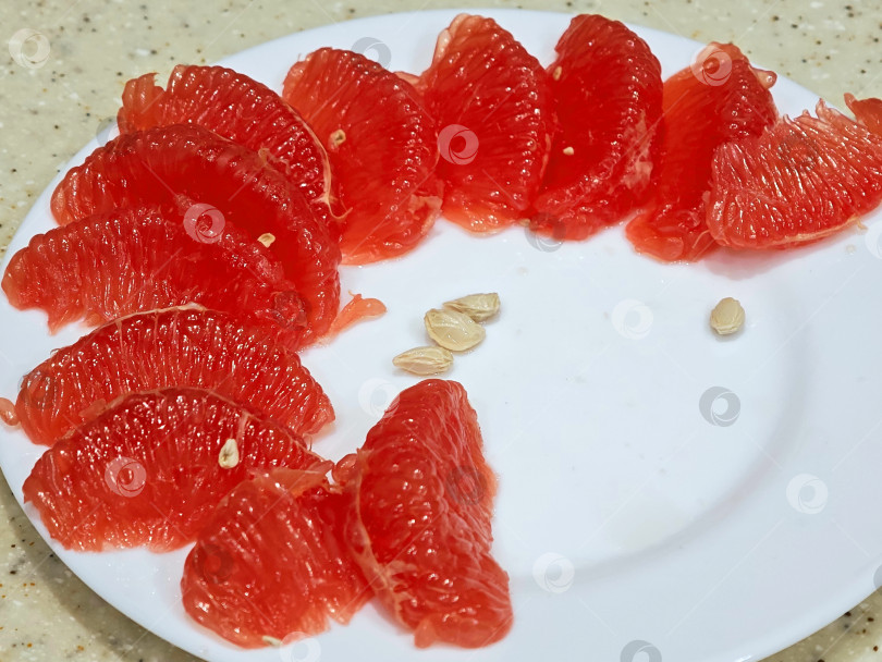 Скачать Красный грейпфрут на белой тарелке. фотосток Ozero