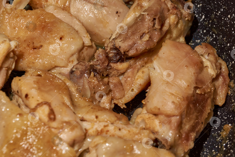 Скачать Жареное куриное мясо крупным планом. Кусочки курицы обжариваются на сковороде. фотосток Ozero