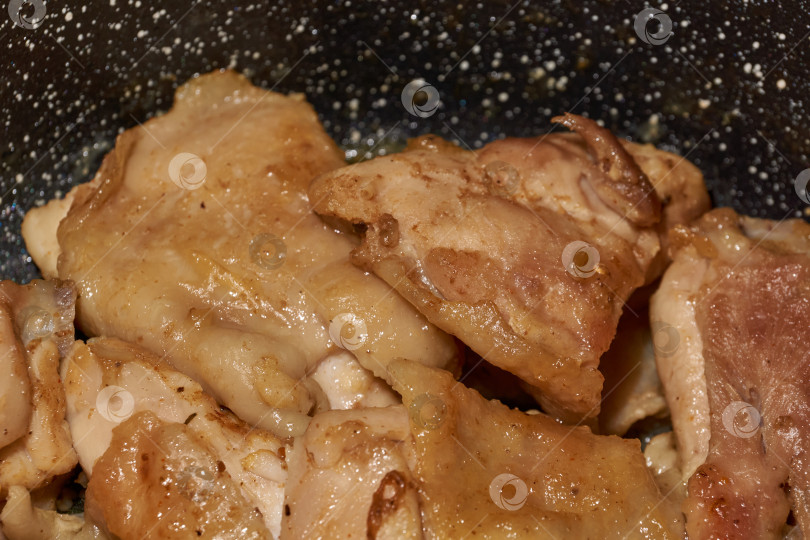 Скачать Жареное куриное мясо крупным планом. Кусочки курицы обжариваются на сковороде. фотосток Ozero