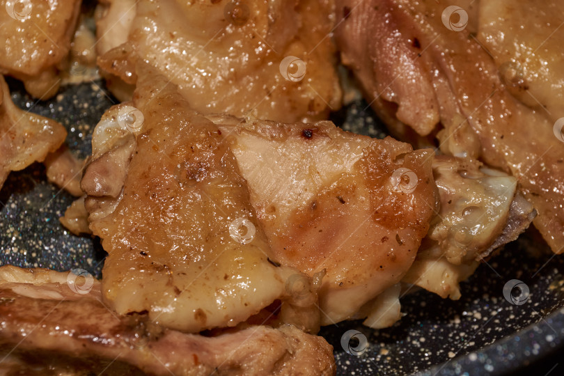 Скачать Жареное куриное мясо крупным планом. Кусочки курицы обжариваются на сковороде. фотосток Ozero