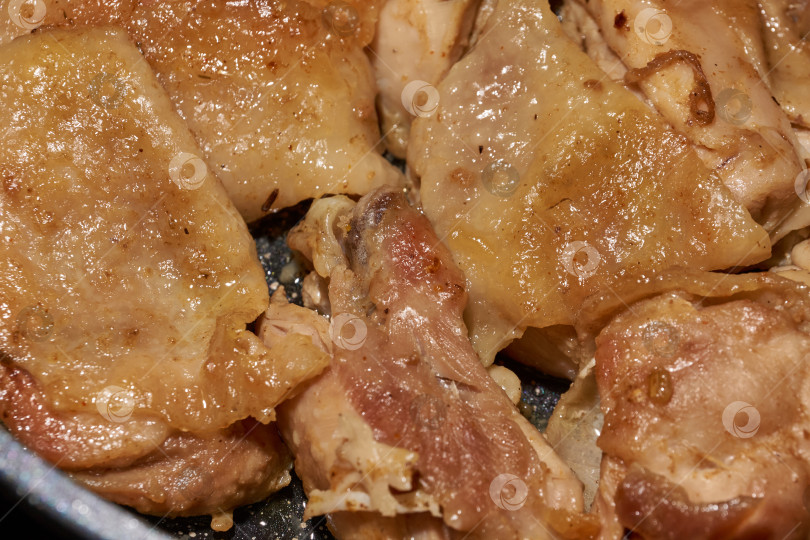 Скачать Жареное куриное мясо крупным планом. Кусочки курицы обжариваются на сковороде. фотосток Ozero