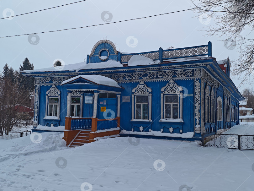 Скачать Детская школа искусств в селе, Синее деревянное старое здание с красивым оформлением. Детская художественная школа в деревне представляет собой старинное здание из синего дерева с красивым декором. фотосток Ozero