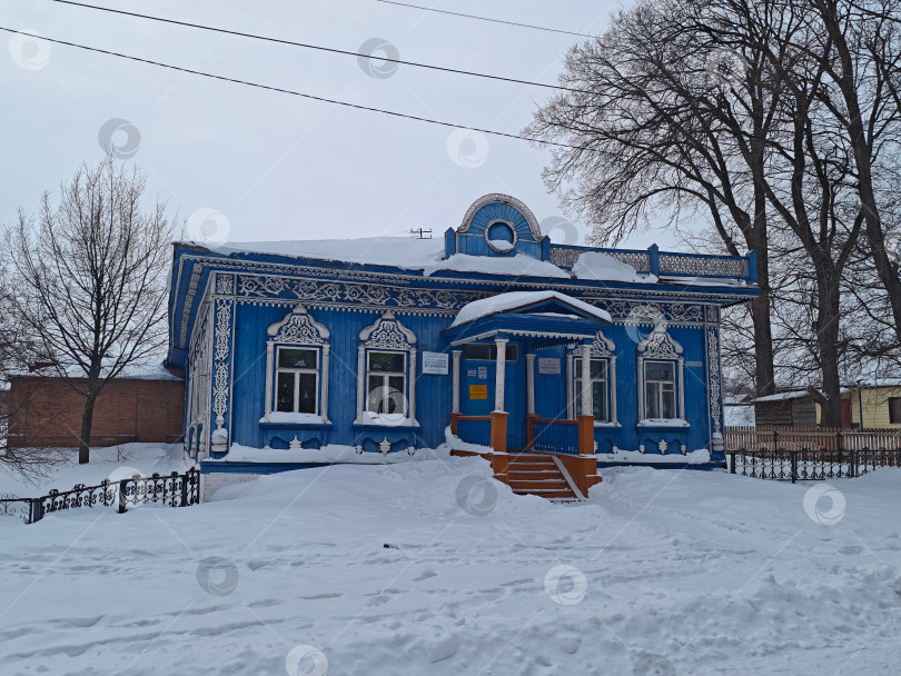 Скачать Детская школа искусств в селе, Синее деревянное старое здание с красивым оформлением. Детская художественная школа в деревне представляет собой старинное здание из синего дерева с красивым декором. фотосток Ozero
