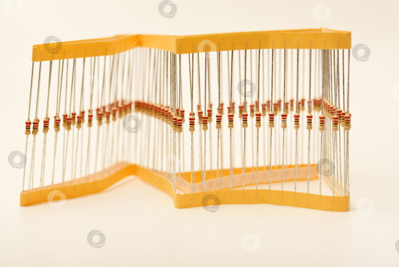 Скачать Упаковка пленочных резисторов. Резисторы с осевыми выводами.  Желтые резисторы в упаковке. фотосток Ozero