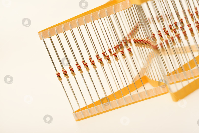 Скачать Упаковка пленочных резисторов. Резисторы с осевыми выводами.  В упаковке резисторы желтого цвета. фотосток Ozero