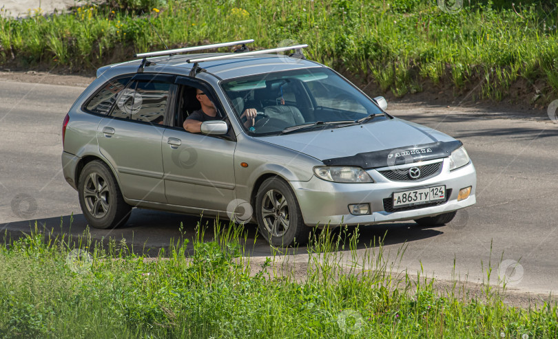 Скачать Россия, Красноярск 27 мая 2025г. автомобиль Mazda Familia Японский автомобиль фотосток Ozero