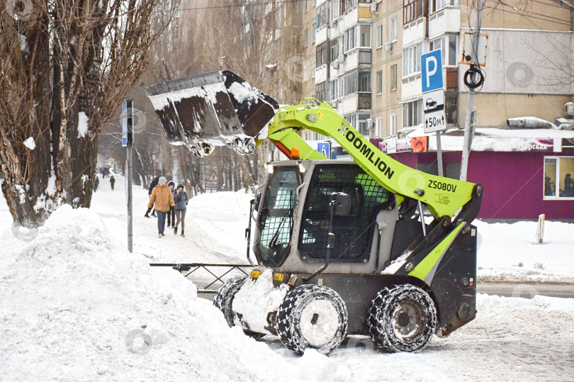 Скачать Погрузчик убирает снег ковшом. фотосток Ozero