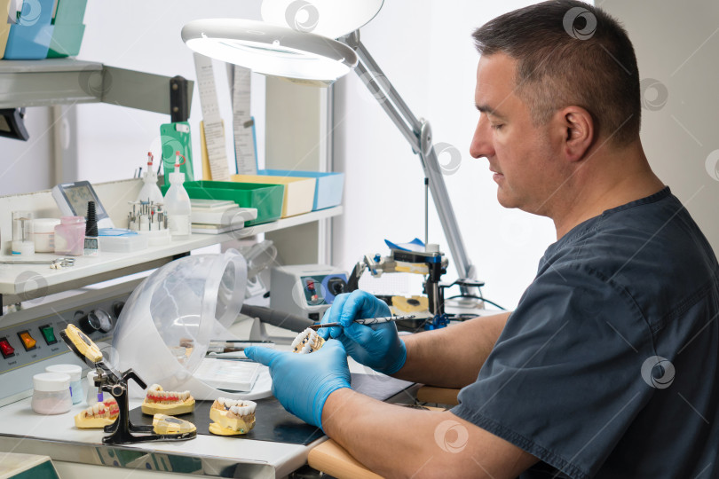 Скачать Зубной техник, работающий с зубным протезом фотосток Ozero